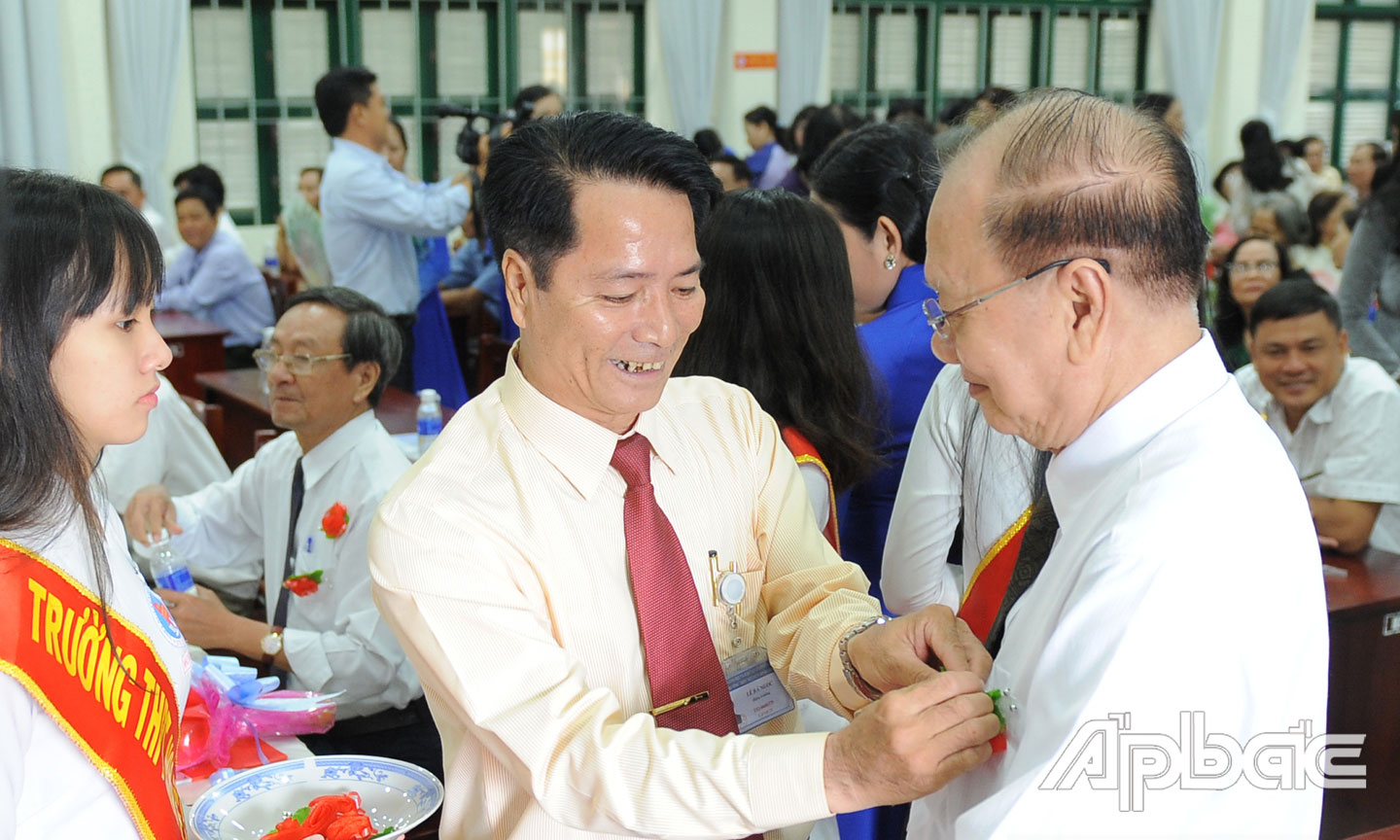Thầy Lê Bá Ngọc, Hiệu trưởng nhà trường cài hoa tri ân thầy Nguyễn Hữu Thông, nguyên Phó Hiệu trưởng nhà trường.