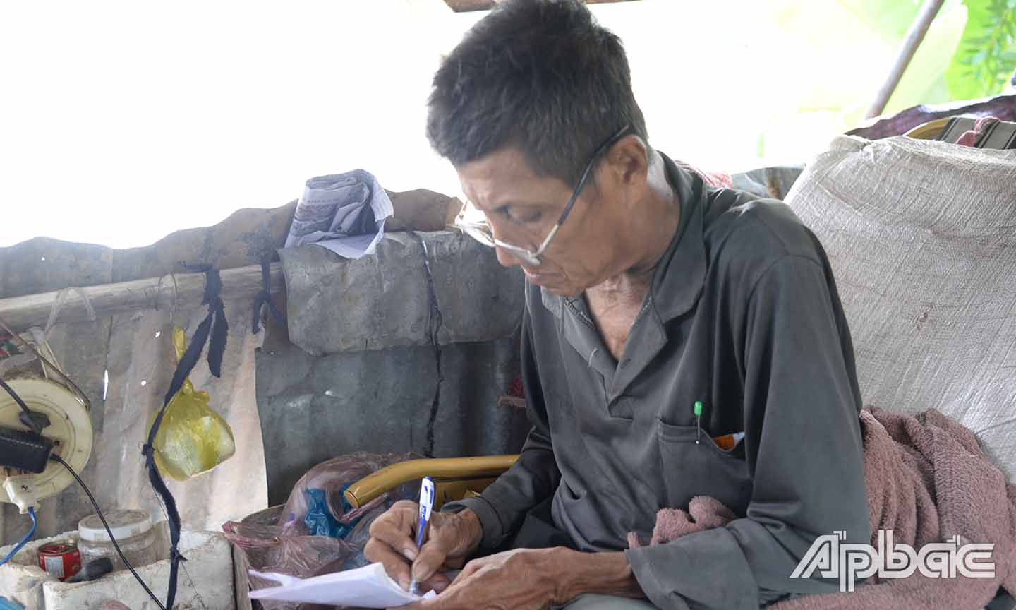 Ông Nguyễn Văn Tiết viết ra giấy kể lại hoàn cảnh của mình do nói chuyện khó khăn vì hạch cổ sưng lớn.