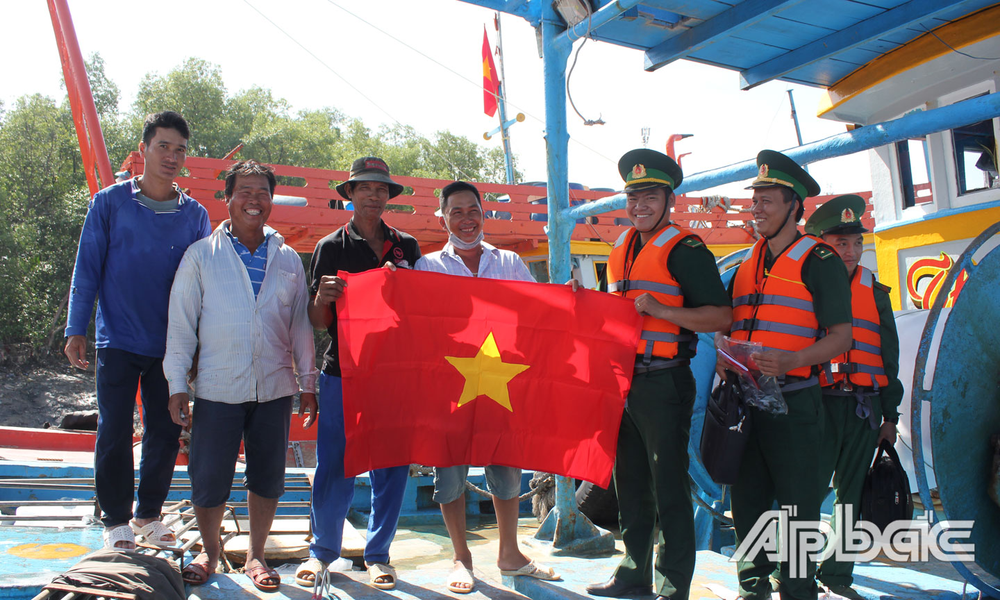 Bộ đội Biên phòng tuyên truyền không vi phạm vùng biển nước ngoài và tặng cờ cho ngư dân trước khi vươn khơi bám biển.