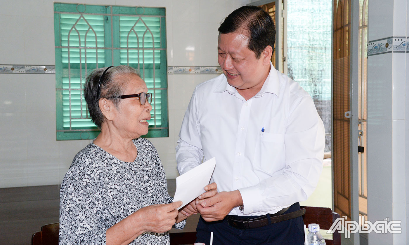 Đồng chí Phan Phùng Phú thăm và tặng quà thương binh, nhân chứng trận Ấp Bắc Trương Thị Nghề (ấp Bắc, xã Tân Phú).