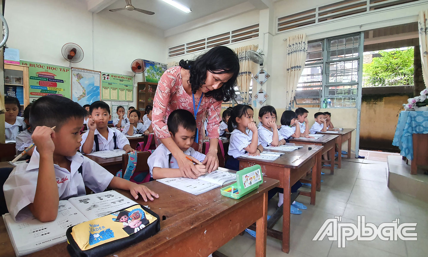 Giáo viên thường xuyên quan tâm, gần gũi, yêu thương, giúp đỡ học trò của mình. (Ảnh chụp tại Trường  Tiểu học Nguyễn Huệ, TP. Mỹ Tho). 