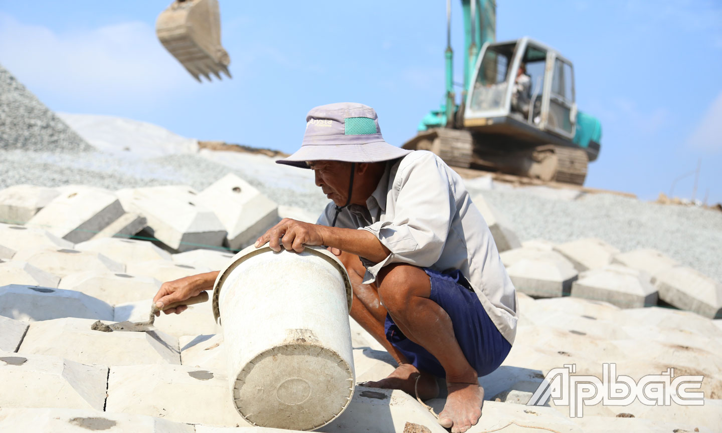 Một công nhân đang tiến hành trám hở trên đê chắn sóng.