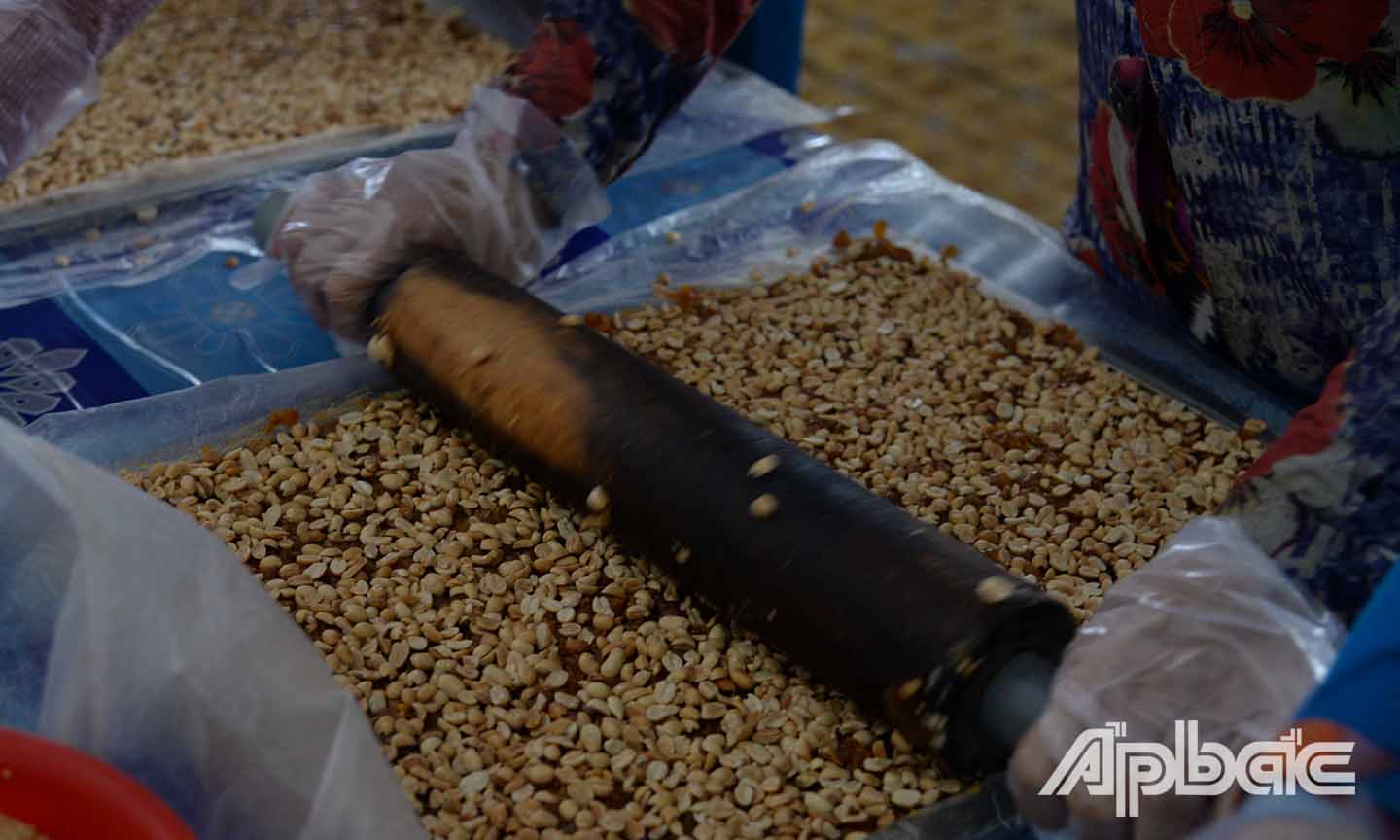 Sau đó, các thợ làm kẹo sẽ ép đậu phộng, mè góp phần làm cho kẹo khóm có hương vị thơm ngon và beo béo.
