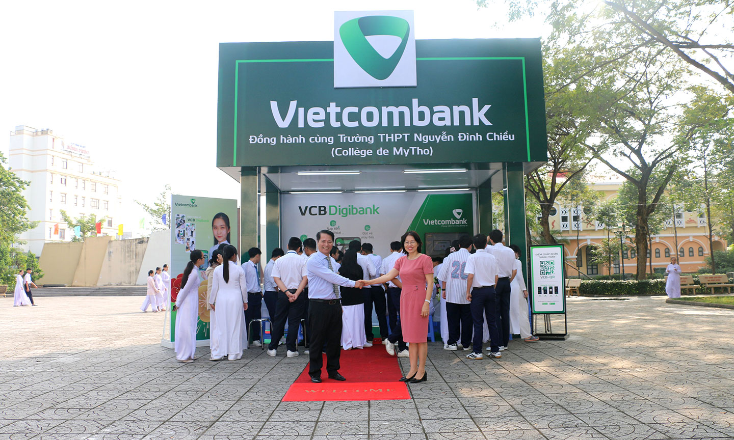 Thầy Lê Bá Ngọc - Hiệu trưởng trường THPT Nguyễn Đình Chiểu và Bà Nguyễn Thị Tuyết - Giám đốc Vietcombank Tiền Giang bắt tay trong buổi lễ khai trương quầy bán hàng.