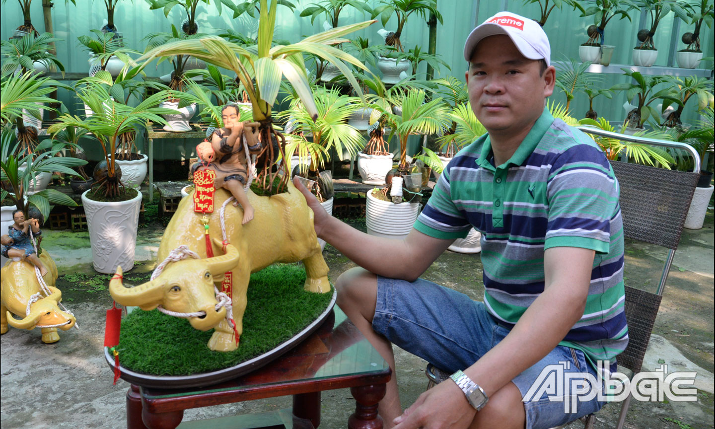 Dừa bonsai được anh Giàu kết hợp với tượng gốm Bát Tràng tạo nên vẻ đẹp độc đáo mà thân thuộc.
