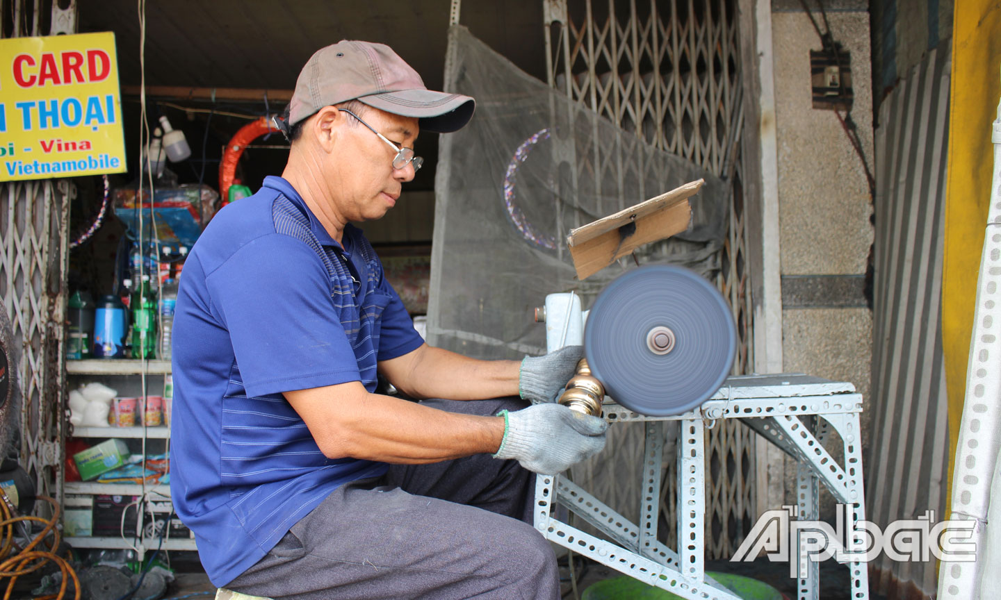 Anh Lê Hoàng Thái đang đánh bóng lư đồng. 