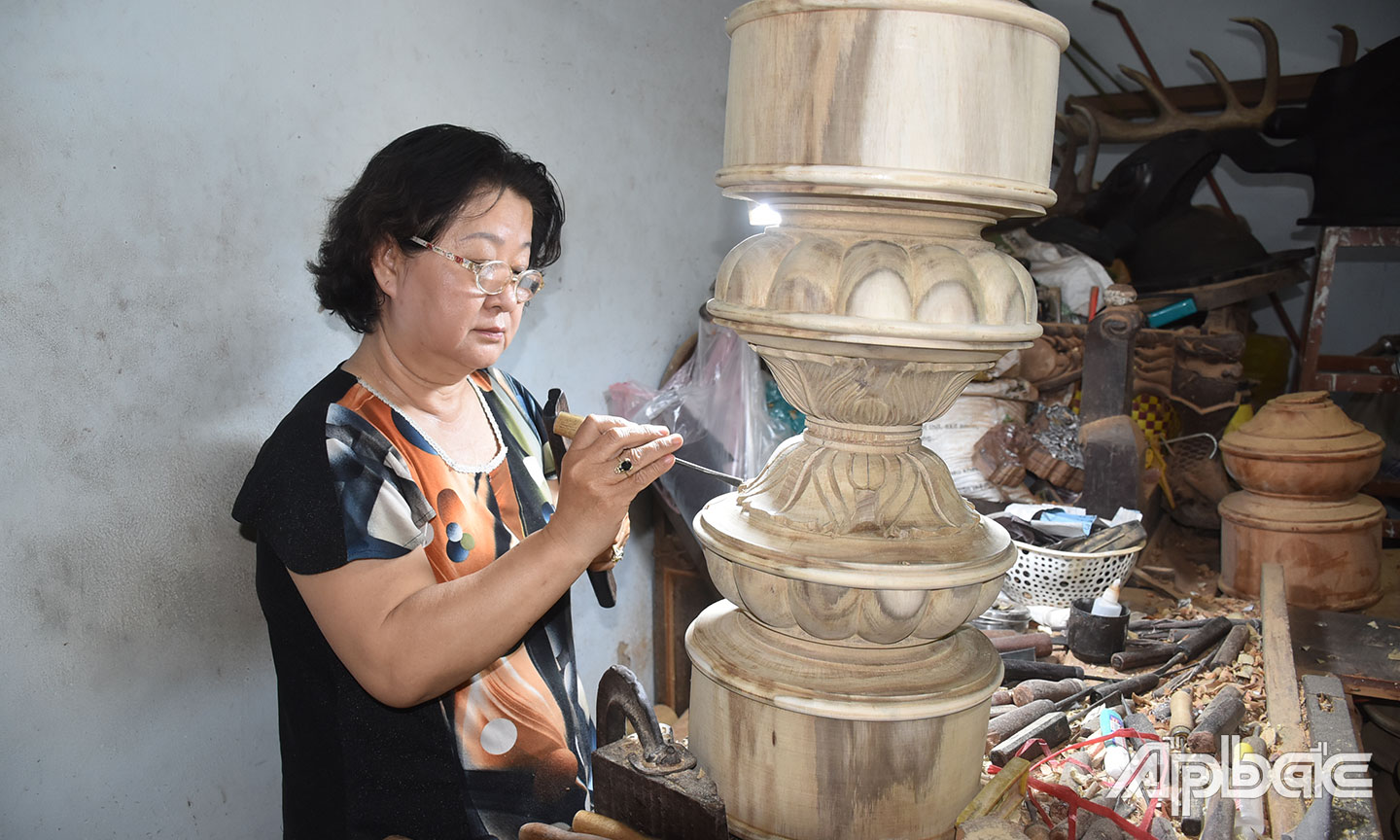 Nghệ nhân Nguyễn Thi Tuyết Huệ đang phục chế tác phẩm.