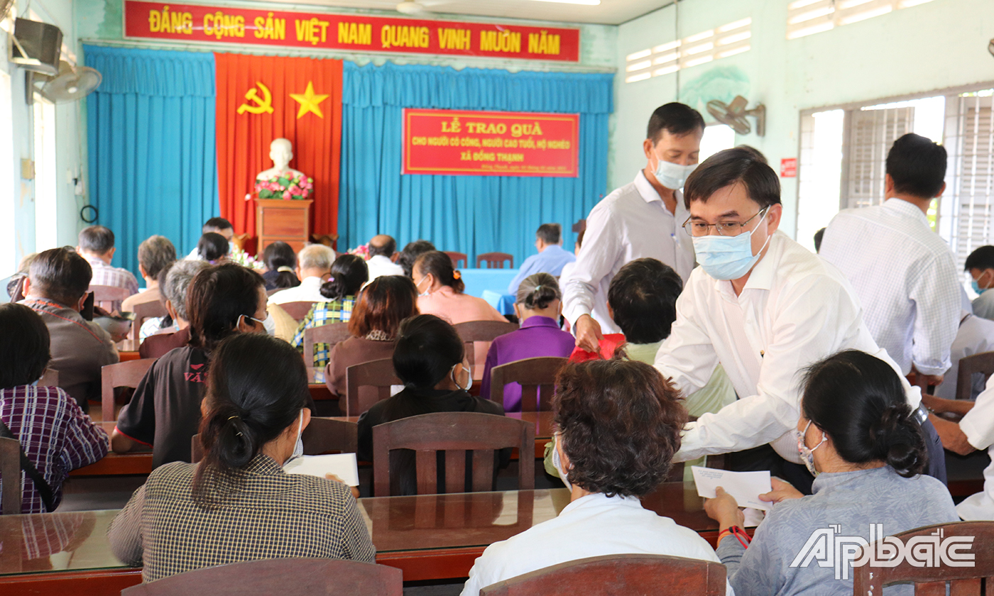 Đồng chí Nguyễn Văn Mười tặng tiền cho các hộ nghèo.