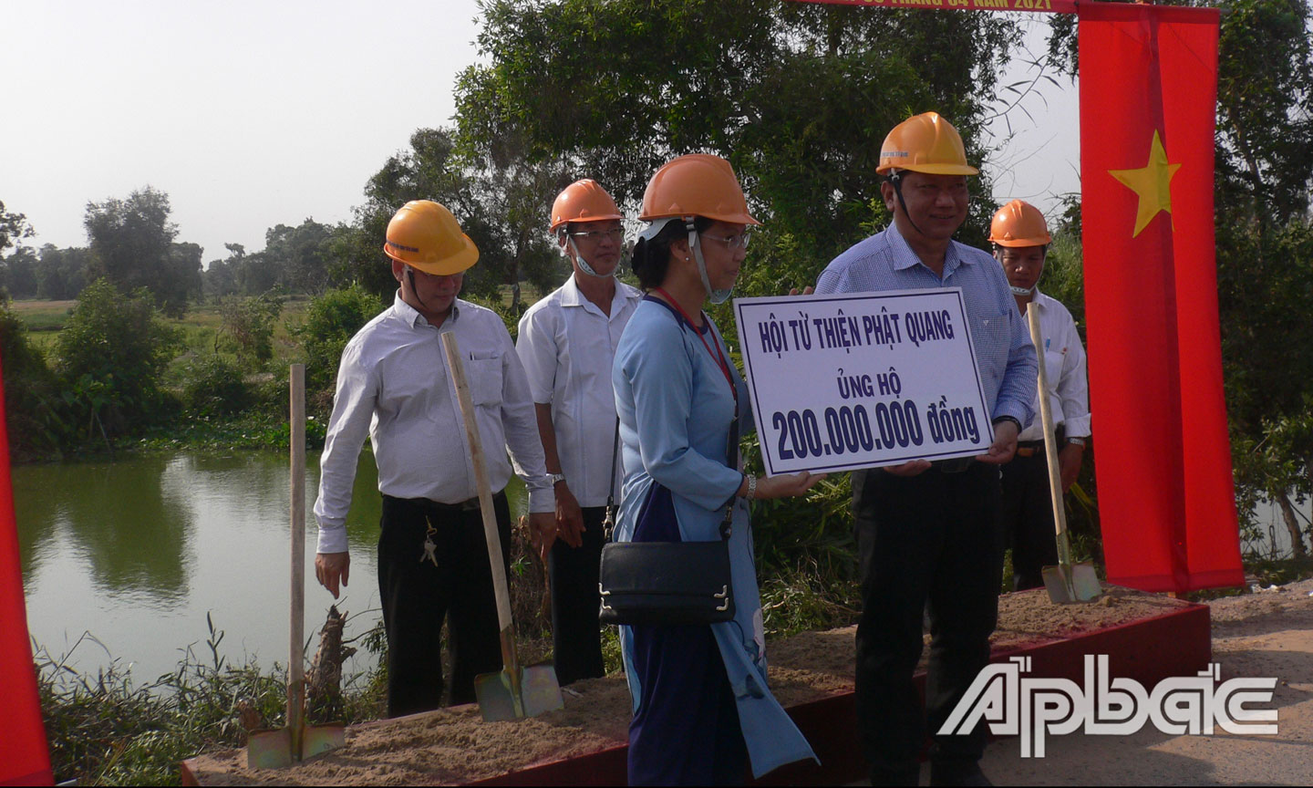 Lễ động thổ, Bà Diệu Ân, đại diện Hội từ thiện chùa Phật Quang trao tiền ủng hộ tượng trưng cho Chính quyền xã Tam Hiệp.