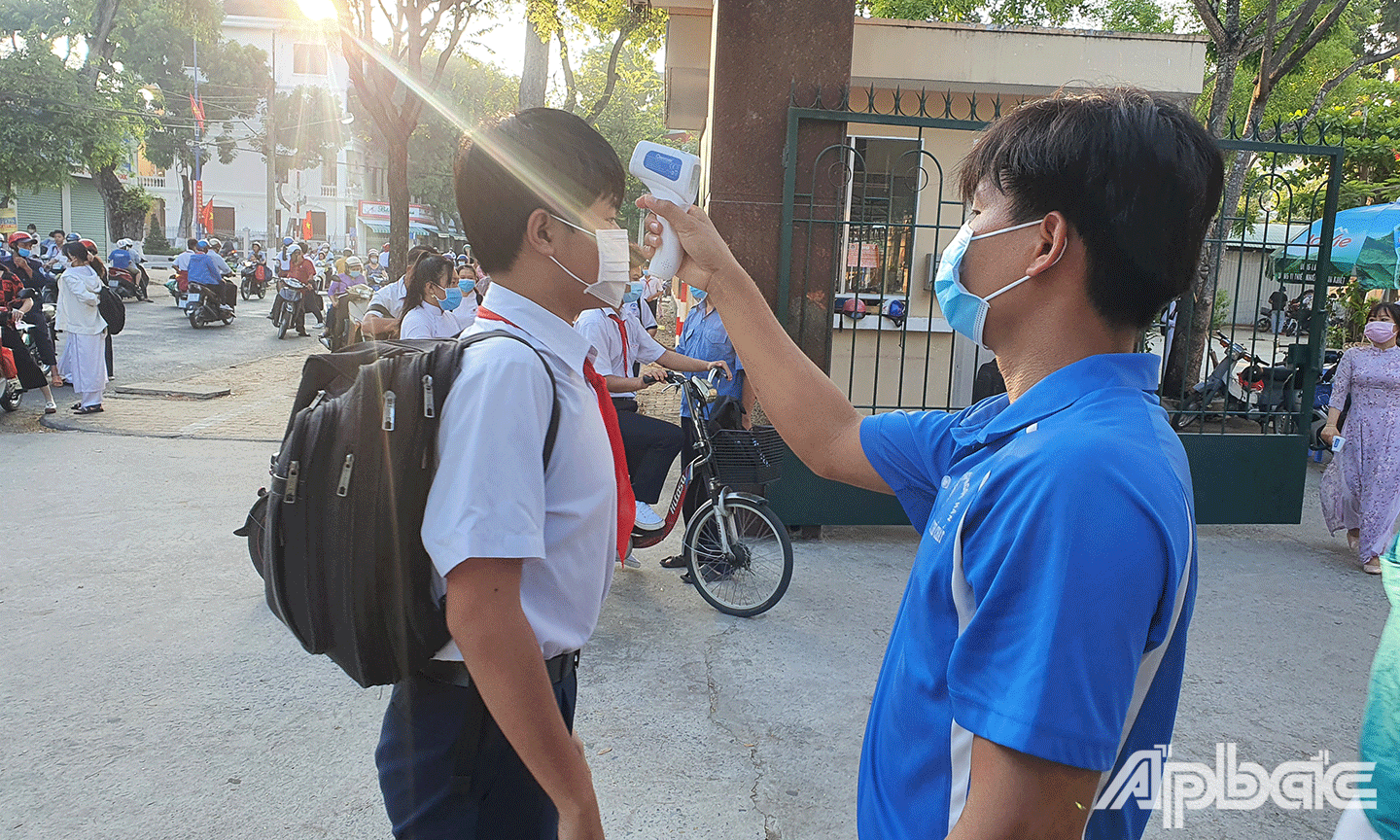 Đo thân nhiệt cho học sinh (Ảnh chụp tại Trường THCS Lê Ngọc Hân, TP. Mỹ Tho). 