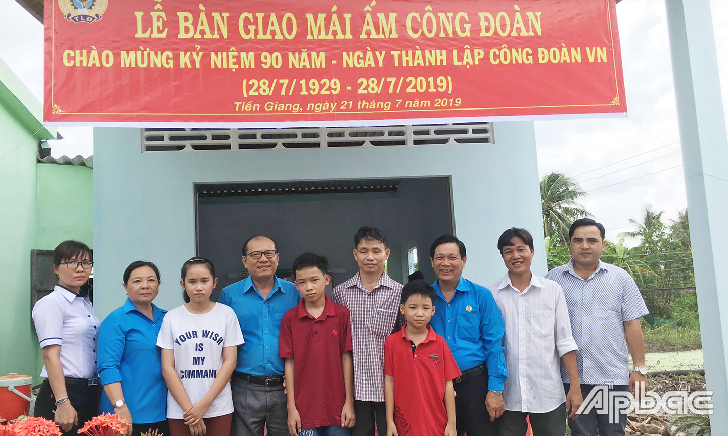 Anh Dũng (thứ tư từ trái sang) trong buổi bàn giao “Mái ấm Công đoàn” cho đoàn viên Công đoàn. 