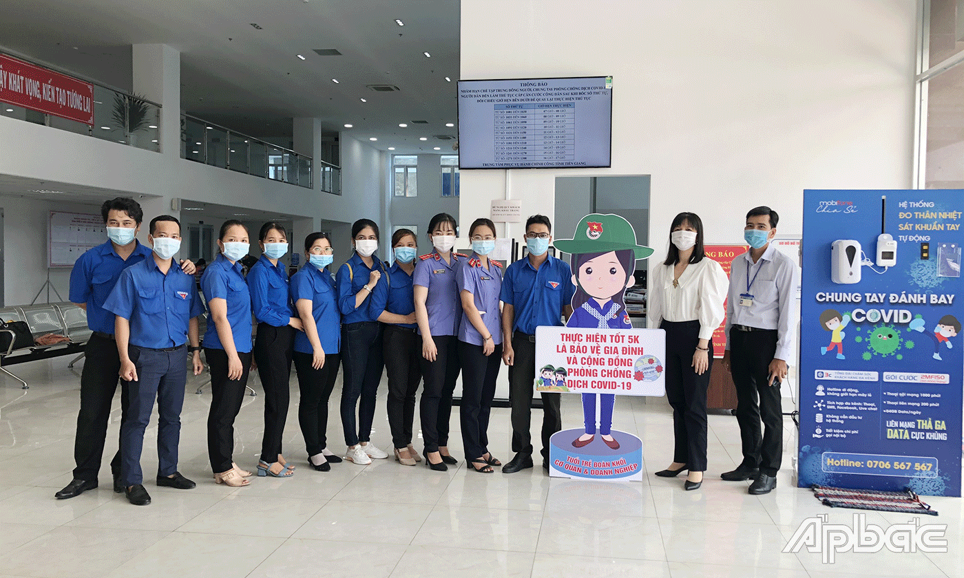 Đoàn viên tặng 1 hình tuyên truyền trực quan phòng chống COVID-19 tại Trung tâm Phục vụ hành chính công tỉnh.