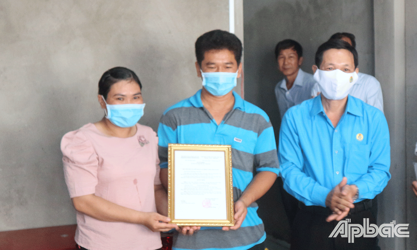 Đồng chí Lê Minh Hùng Chủ tịch Liên đoàn Lao động tỉnh Tiền Giang trao Quyết định bàn giao nhà cho anh Thắng