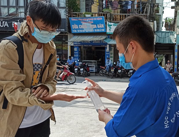 Thí sinh được xịt khử khuẩn trước khi vào điểm thi tốt nghiệp trung học phổ thông quốc gia 2020. (Ảnh: PM/Vietnam+)