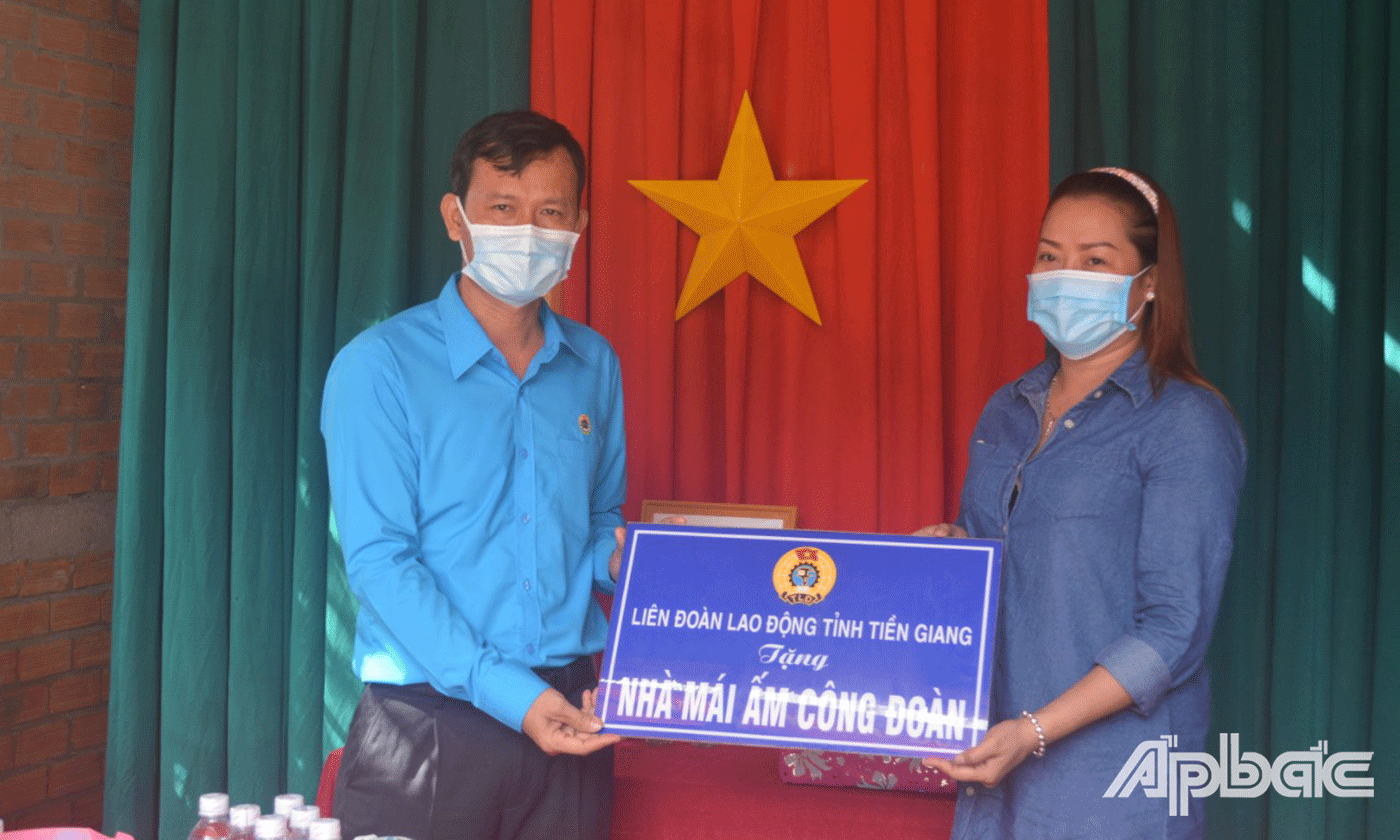 Chị Trịnh Vân Anh, vui mừng nhận bảng tượng trưng trao tặng nhà Mái ấm Công đoàn từ lãnh đạo LĐLĐ tỉnh Tiền Giang