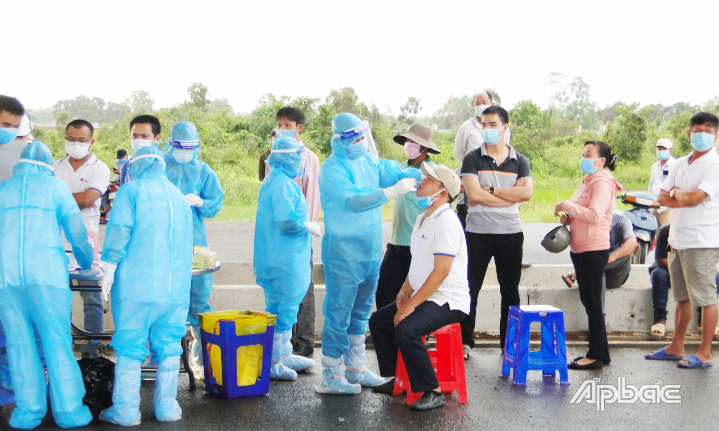 Cán bộ Trung tâm kiểm soát bệnh tật lấy mẫu xét nghiệm SARS-CoV-2 cho công dân về từ Malaysia vào sáng 5-11