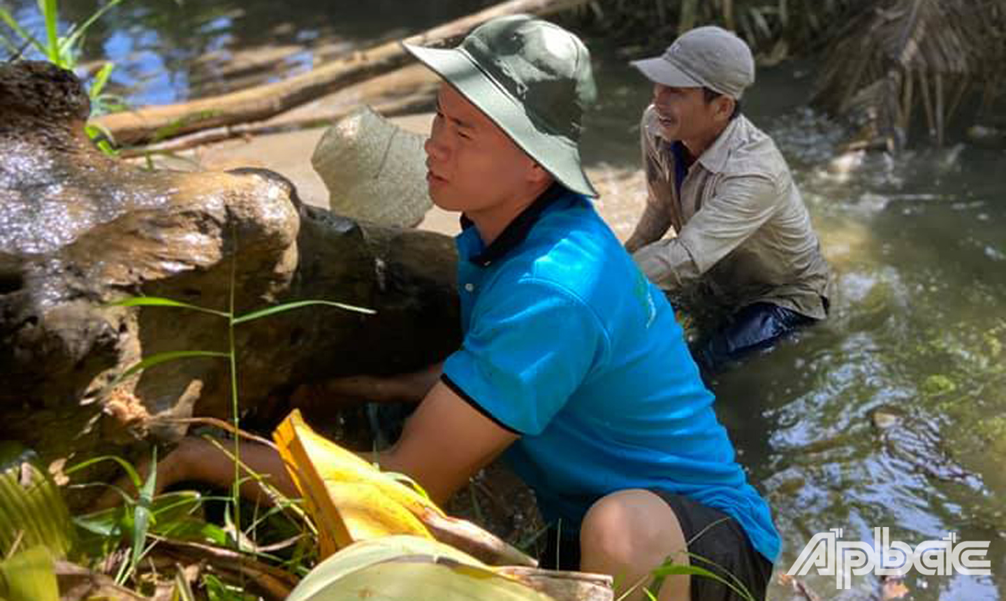  ĐVTN Xã Long Hưng phối hợp cùng Ban Quản lý ấp Long Thanh A, người  dân và sinh viên Đai học Cảnh sát khai thông dòng chảy (Ảnh: Tuổi trẻ Long Hưng) 