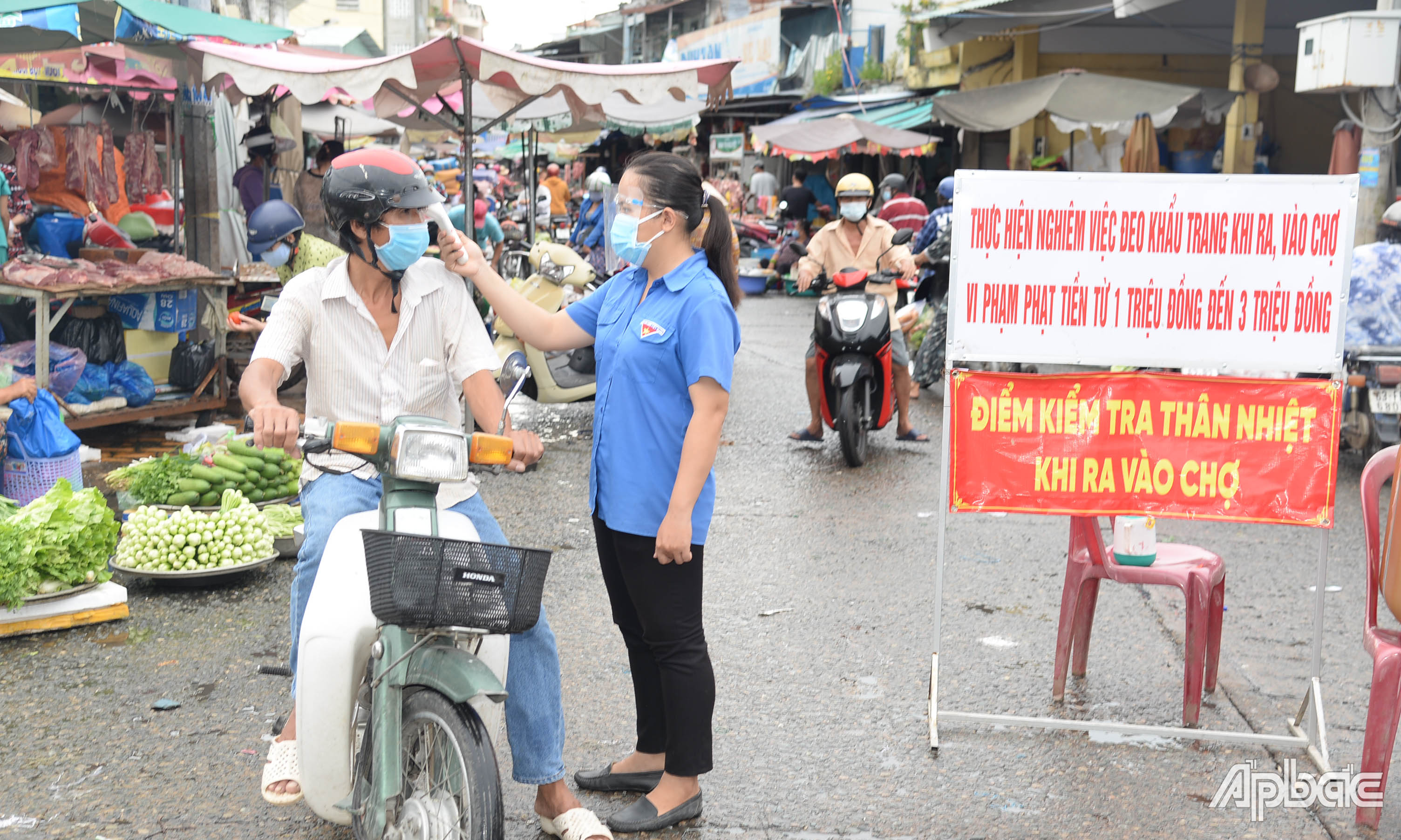 Người dân được đo thân nhiệt khi ra vào chợ phường 1, TP. Mỹ Tho.