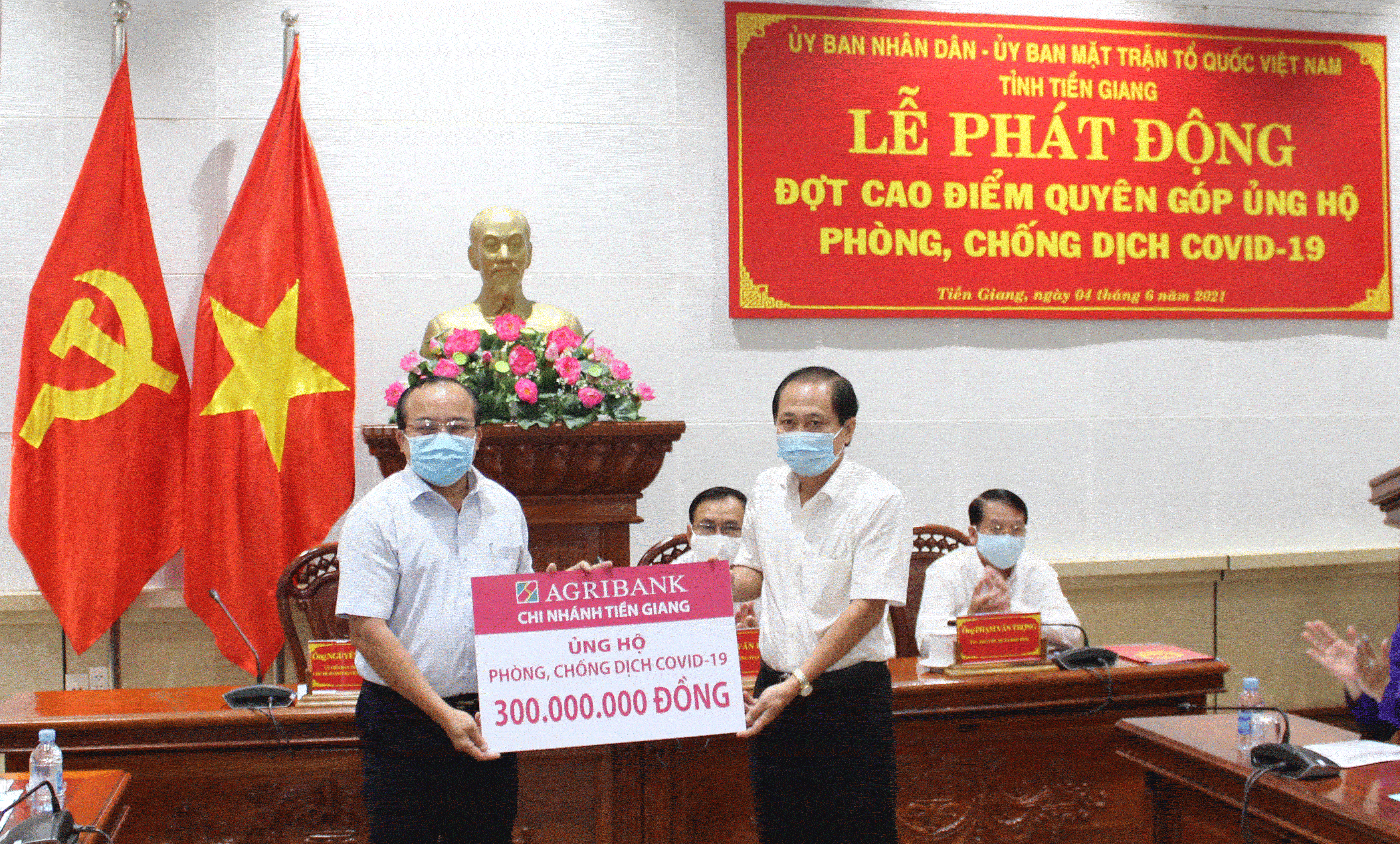 Giám đốc Agribank Tiền Giang Nguyễn Văn Huỳnh (bên phải) trao biển tượng trưng 300 triệu đồng ủng hộ phòng chống dịch Covid-19 cho Ông Nguyễn Chí Trung - Chủ tịch UBMTTQVN Tỉnh Tiền Giang.