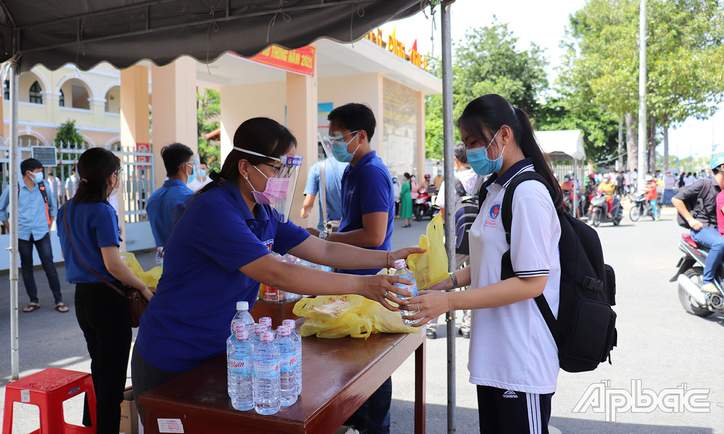 Đội tiếp sức mùa thi tại Điểm thi trường THPT Nguyễn Đình Chiểu (TP. Mỹ Tho) hỗ trợ nước và bánh cho thí sinh. 		
