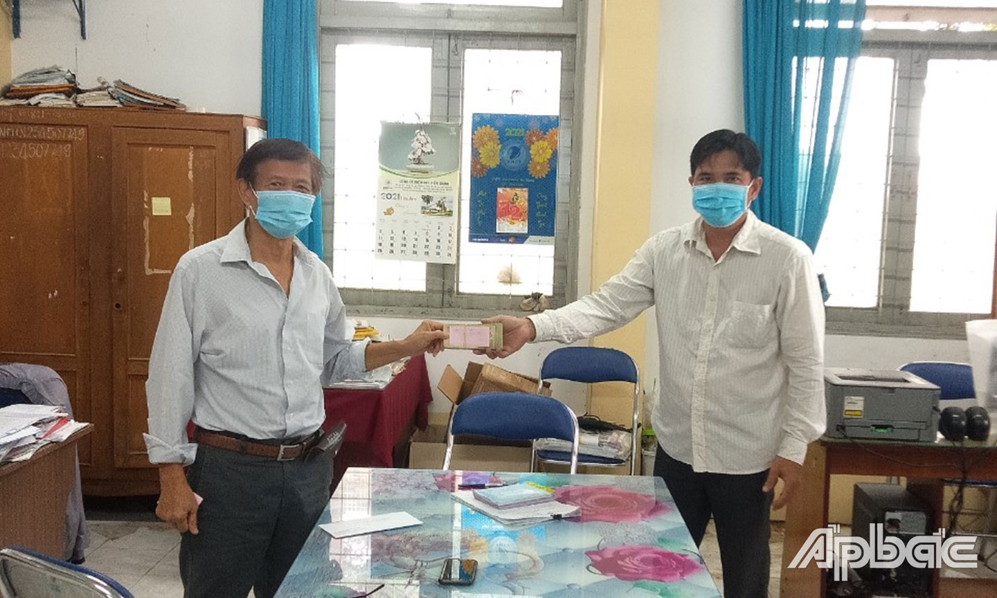 Ông Huỳnh Văn Quang trao tiền ủng hô quỹ Covid 19( người đứng bên trái)