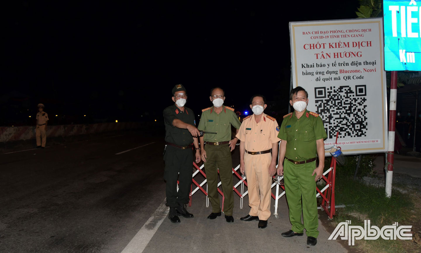 Đại tá Nguyễn Văn Nhựt,  Giám đốc Công an tỉnh và Đại tá Nguyễn Văn Lộc, Phó Giám đốc  Công an tỉnh động viên lực lượng  thực hiện nhiệm vụ tại chốt kiểm soát trên Quốc lộ 1 (xã Tân Hương,  huyện Châu Thành). Ảnh: THANH VIỆT