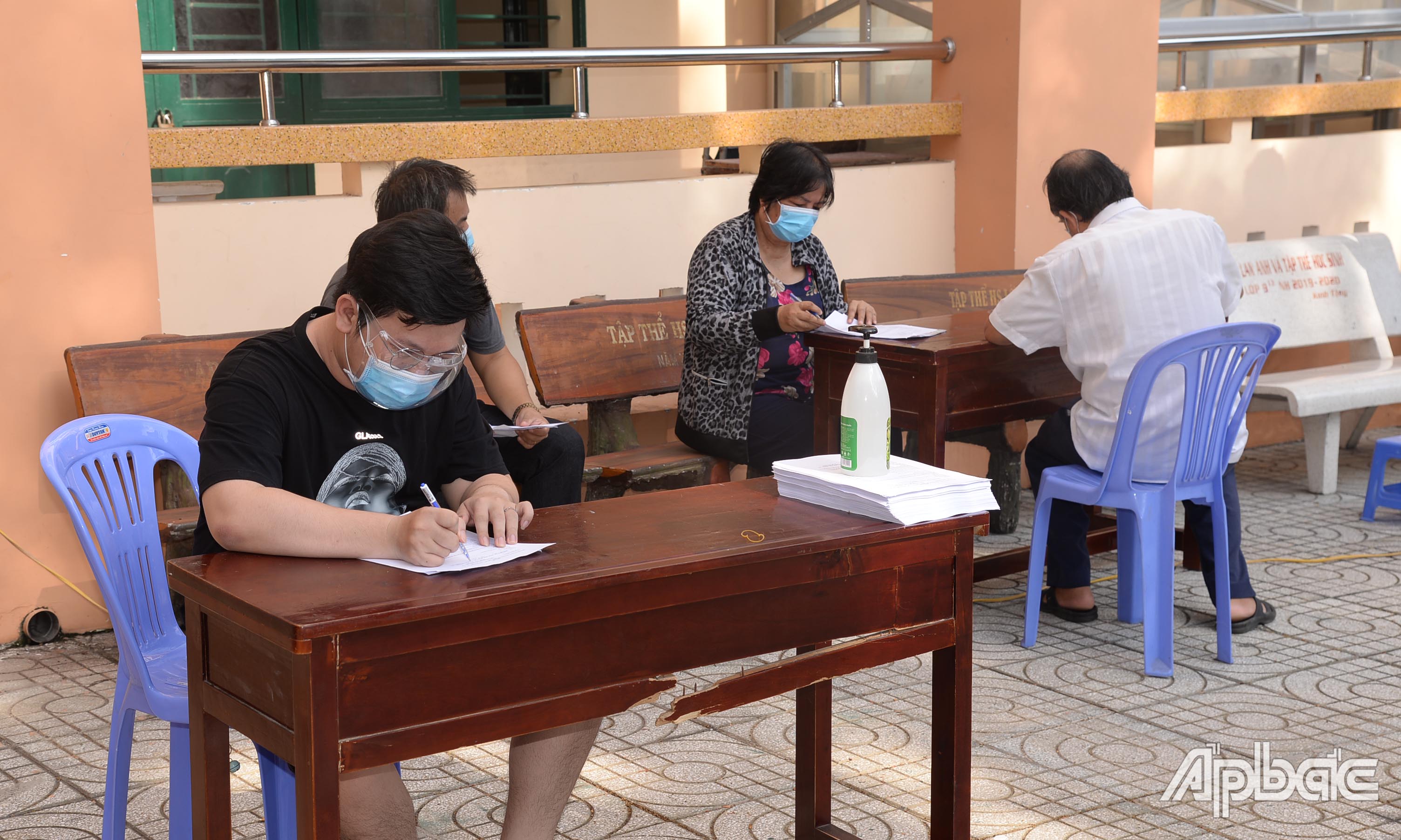 Người dân khai báo thông tin trước khi tiêm vắc xin Covid-19 tại điểm tiêm Trường THCS Lê Ngọc Hân.