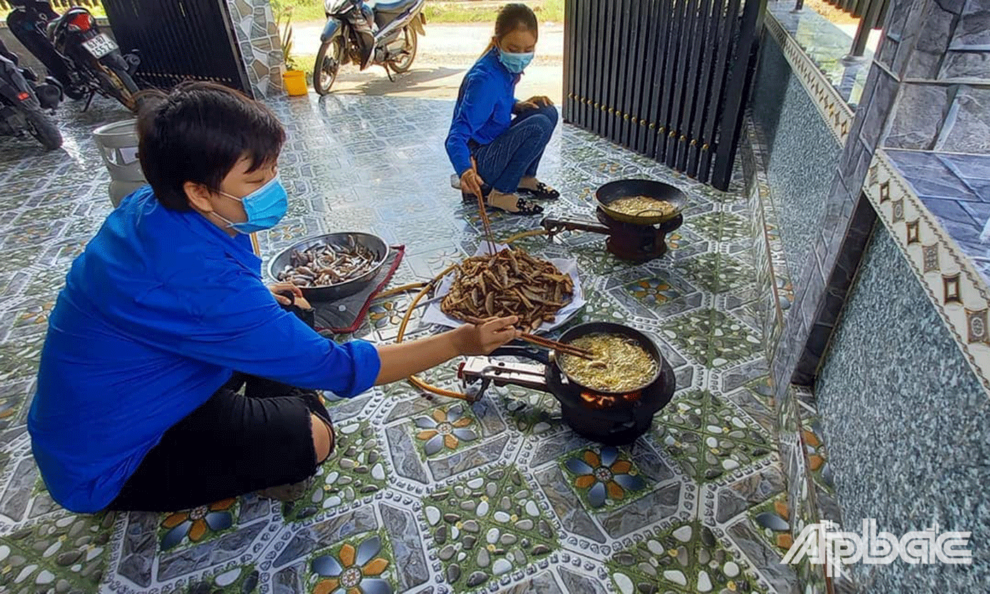 Đoàn viên thanh niên tình nguyện đang nấu nướng chuẩn bị các phần cơm 