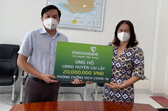Bà Nguyễn Thị Tuyết, Giám đốc Vietcombank Tiền Giang trao tiền hỗ trợ phòng chống dịch Covid-19 tại huyện Cai Lậy.