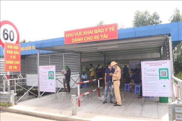 Lực lượng Cảnh sát giao thông hướng dẫn các lái xe khai báo tại khu vực khai báo y tế tự động tại chốt kiểm soát cầu Bạch Đằng (thị xã Quảng Yên, tỉnh Quảng Ninh), ngày 7/10/2021. (Ảnh: Thanh Vân/TTXVN)