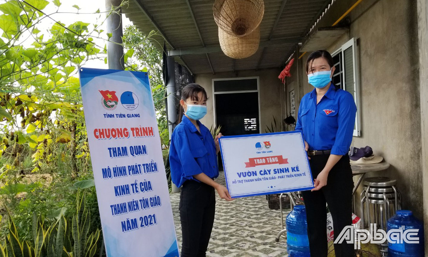 Đồng chí Nguyễn Thị Mỹ Nương trao Bảng tượng trưng hỗ trợ vườn cây sinh kế cho thanh niên tôn giáo phát triển kinh tế. 