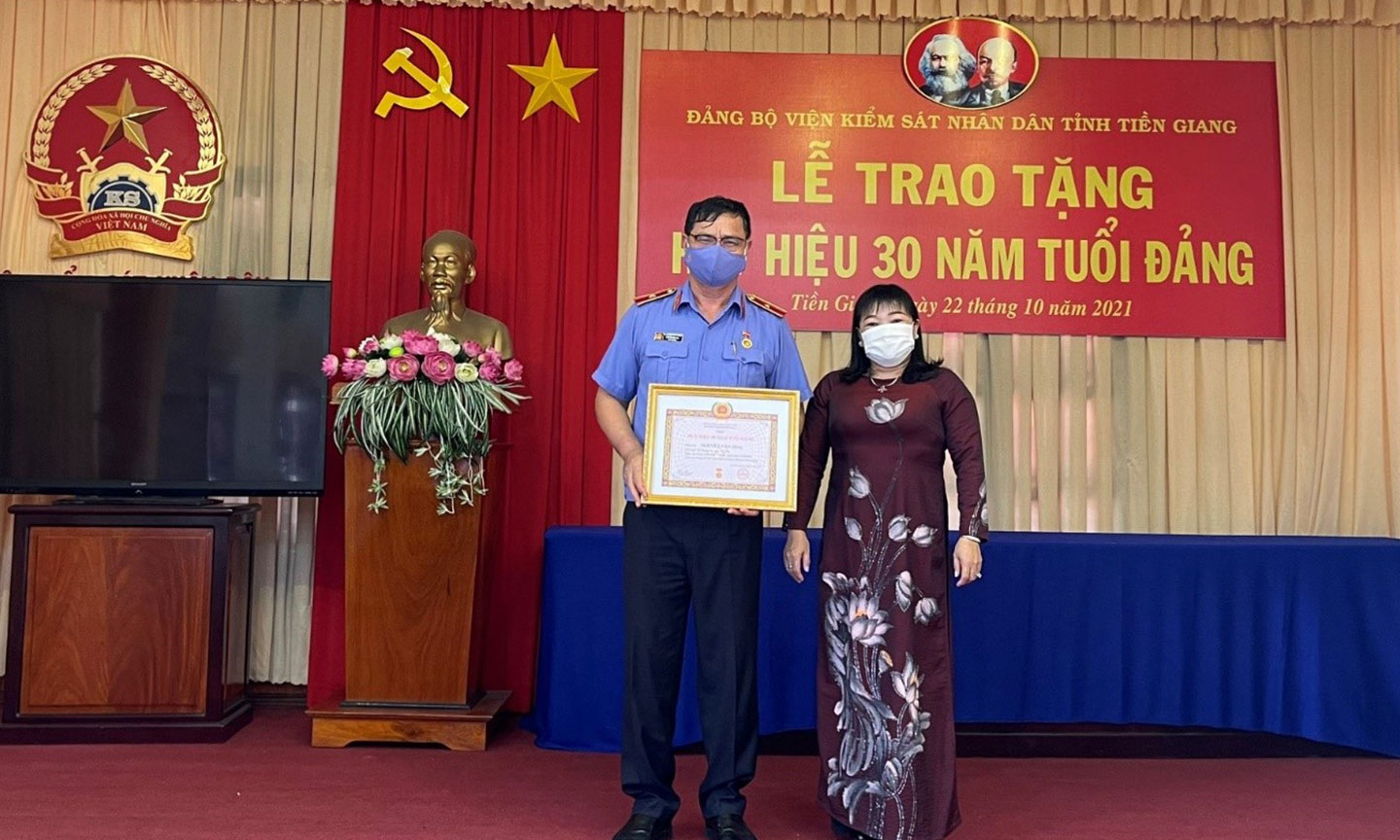 Đ/c Thái Ngọc Bảo Trâm, Tỉnh ủy viên, Bí thư Đảng ủy Khối cơ quan và doanh nghiệp tỉnh trao quyết định và Huy hiệu 30 năm tuổi Đảng cho đ/c Nguyễn Văn Hòa.