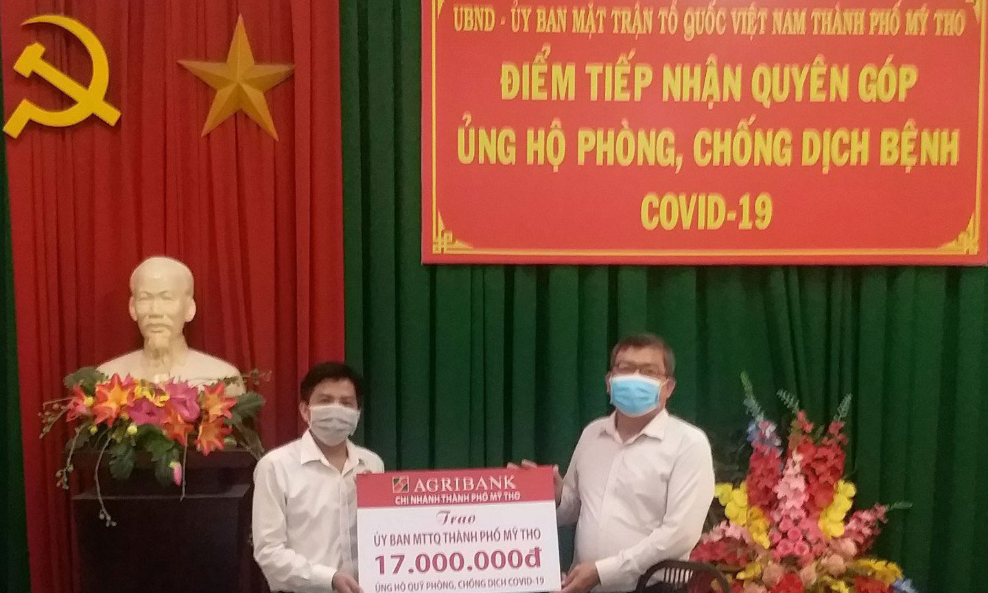 Chủ tịch Ủy ban MTTQ TP. Mỹ Tho (bên phải) nhận biển tượng trưng số tiền ủng hộ từ ông Huỳnh Thanh Hải, Phó Giám đốc phụ trách Agribank TP. Mỹ Tho.