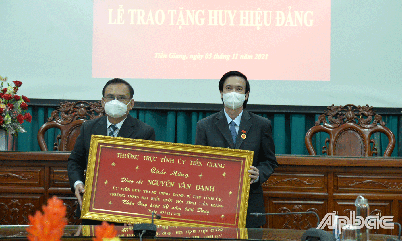 Đồng chí Võ Văn Bình tặng quà của Ban Thường vụ Tỉnh ủy cho đồng chí Nguyễn Văn Danh.