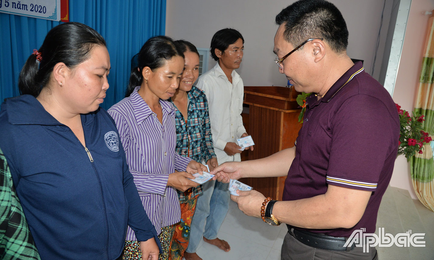 Giám đốc BHXH Tiền Giang Võ Khánh Bình trao tặng thẻ BHYT cho các hộ gia đình làm nông nghiệp có mức sống trung bình ở huyện Tân Phước (ảnh chụp trước khi dịch Covid-19 bùng phát).