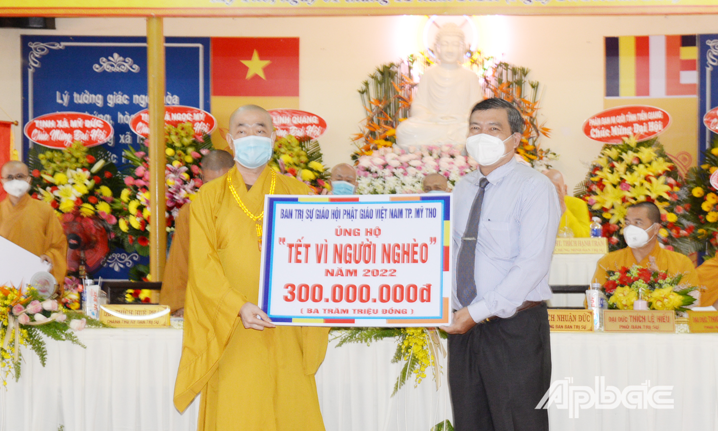 Thượng tọa Thích Quảng Lộc trao bảng tượng trưng ủng hộ 300 triệu đồng cho chương trình Tết vì người nghèo đến đồng chí Bùi Văn Bảo, Chủ tịch Ủy ban MTTQ TP. Mỹ Tho