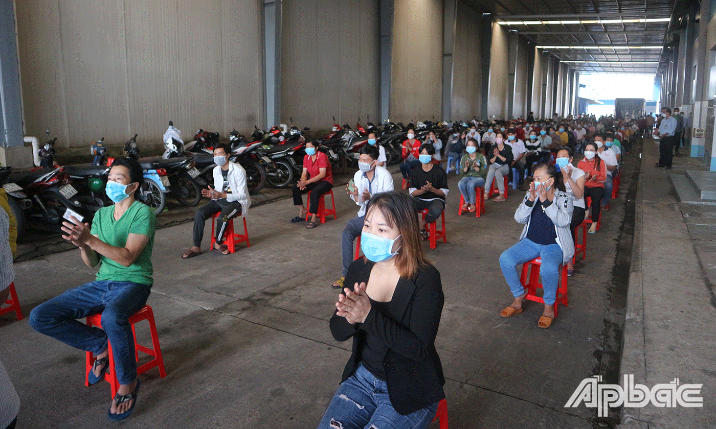 Công nhân, lao động ngồi xếp hàng trật tự, giữ khoảng cách chờ đến lượt nhận hỗ trợ