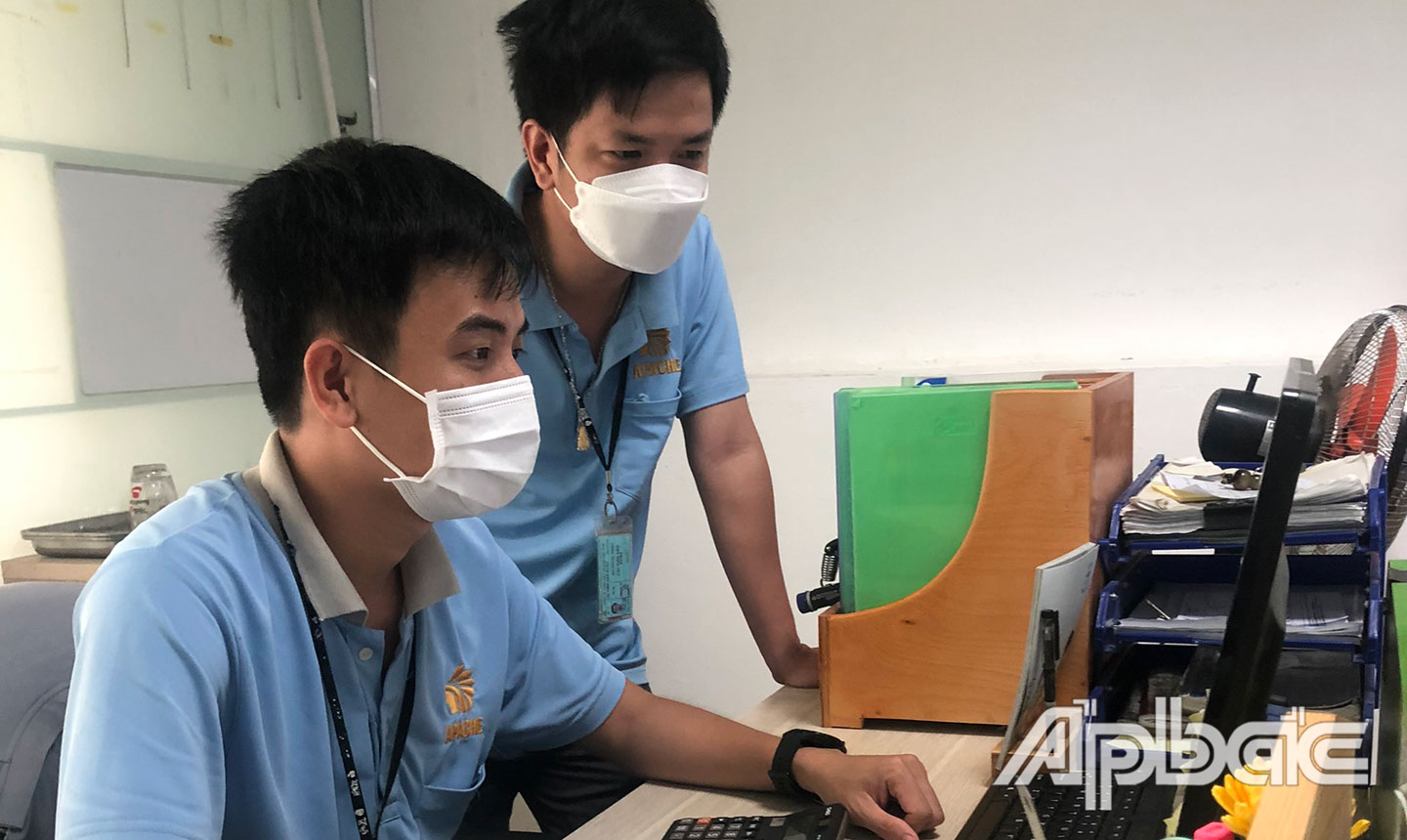 Anh Phạm Minh Trung (ngồi ghế) đang trao đổi công việc với đồng nghiệp.