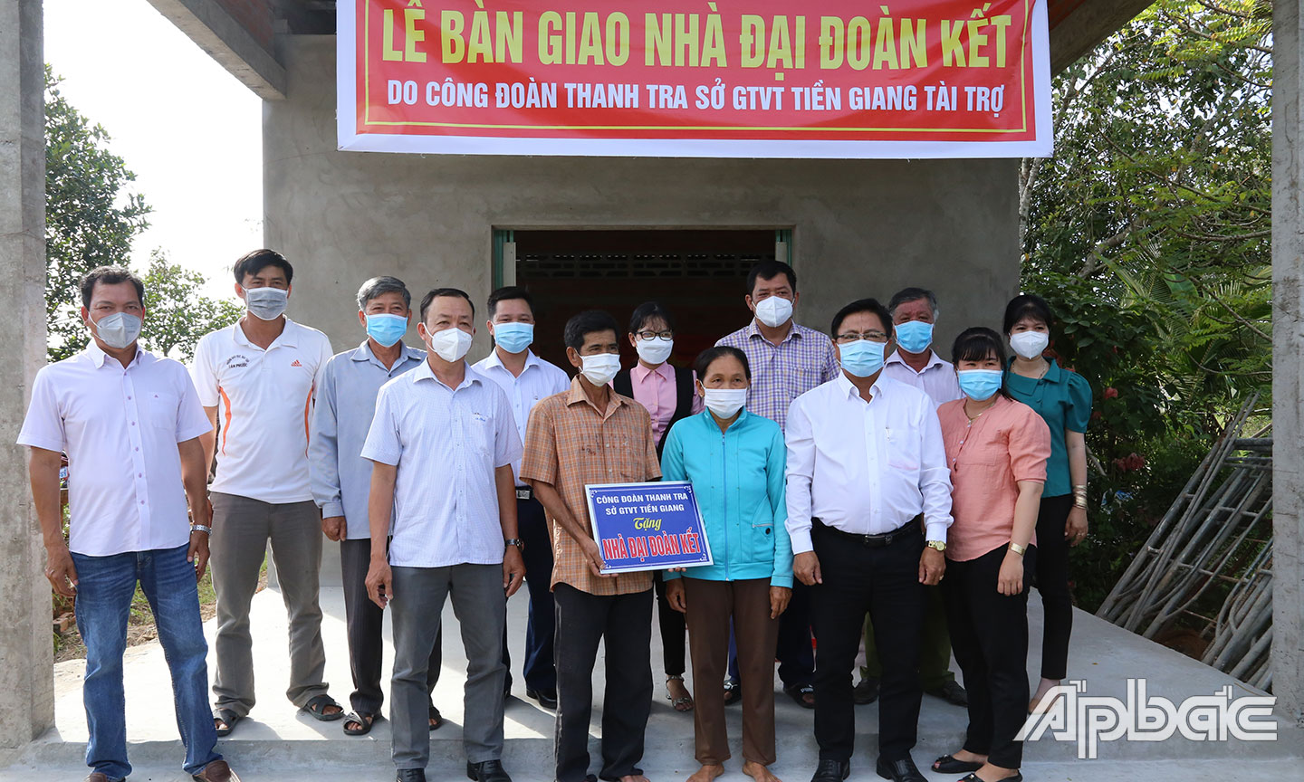 Các đại biểu tham gia bàn giao chụp ảnh trước nhà ông Bảy.