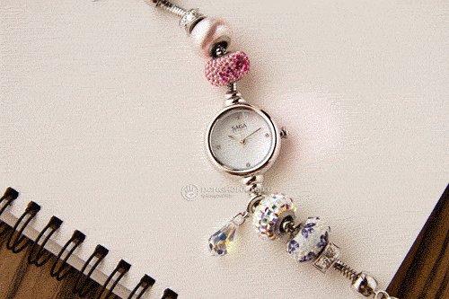 Saga Charm là sự kết hợp độc đáo của mặt số đồng hồ và vòng tay Charm, đi cùng với hàng trăm viên đá pha lê lấp lánh.