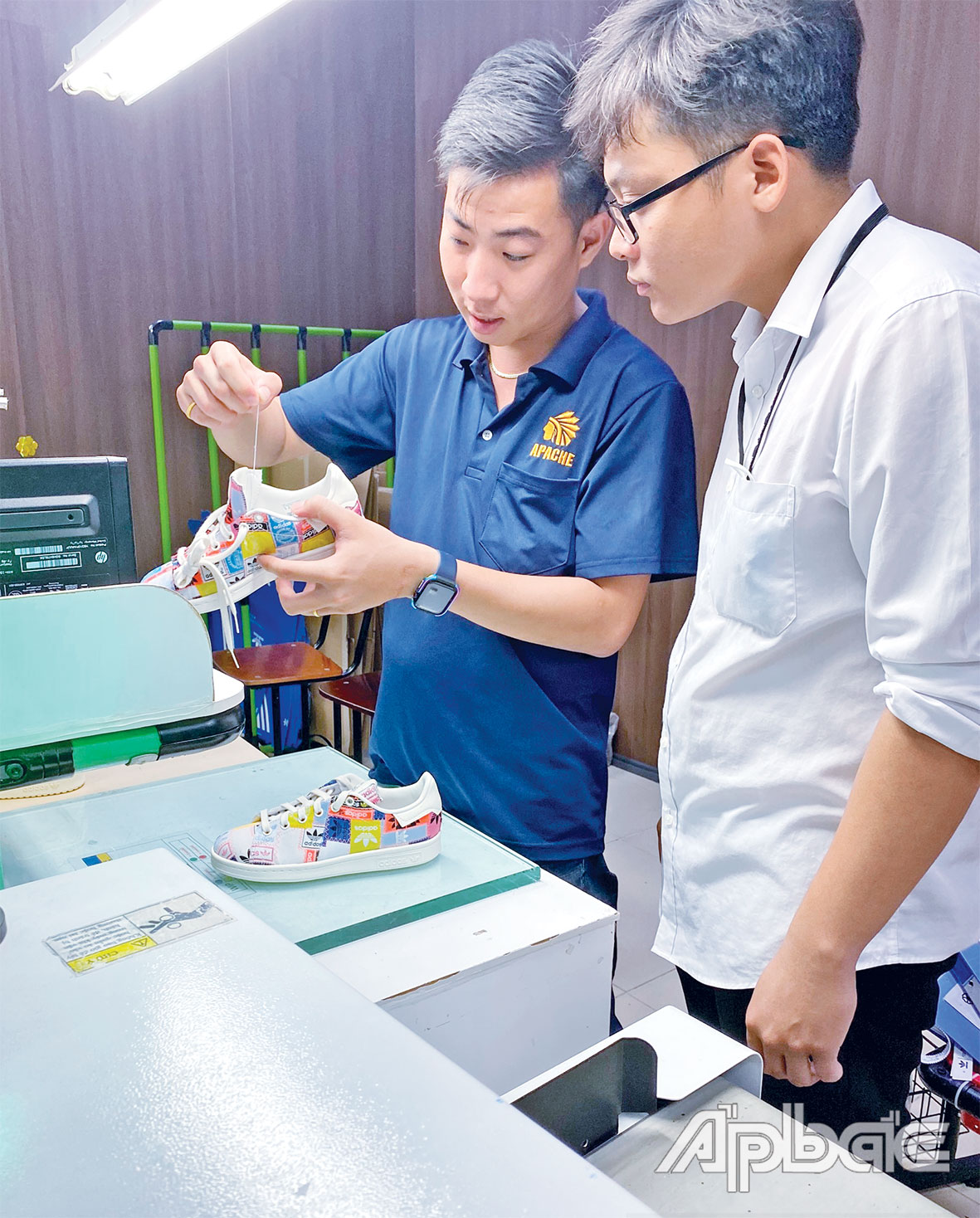 Anh Phạm Đình Nam (áo xanh) hướng dẫn đồng nghiệp quy trình sản xuất giày.