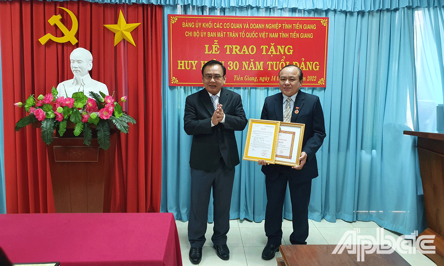 Đồng chí Võ Văn Bình, Phó Bí thư Thường trực Tỉnh ủy, Chủ tịch Hội đồng nhân dân tỉnh Tiền Giang  trao Huy hiệu 30 năm tuổi Đảng cho đồng chí Nguyễn Chí Trung.