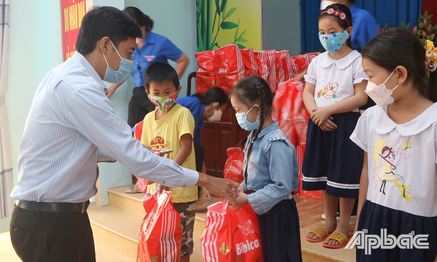 Nguyễn Quang Minh, Phó Bí thư Tỉnh đoàn Tiền Giang trao quà tết cho các em học sinh khó khăn trên địa bàn huyện Gò Công Tây, tỉnh Tiền Giang