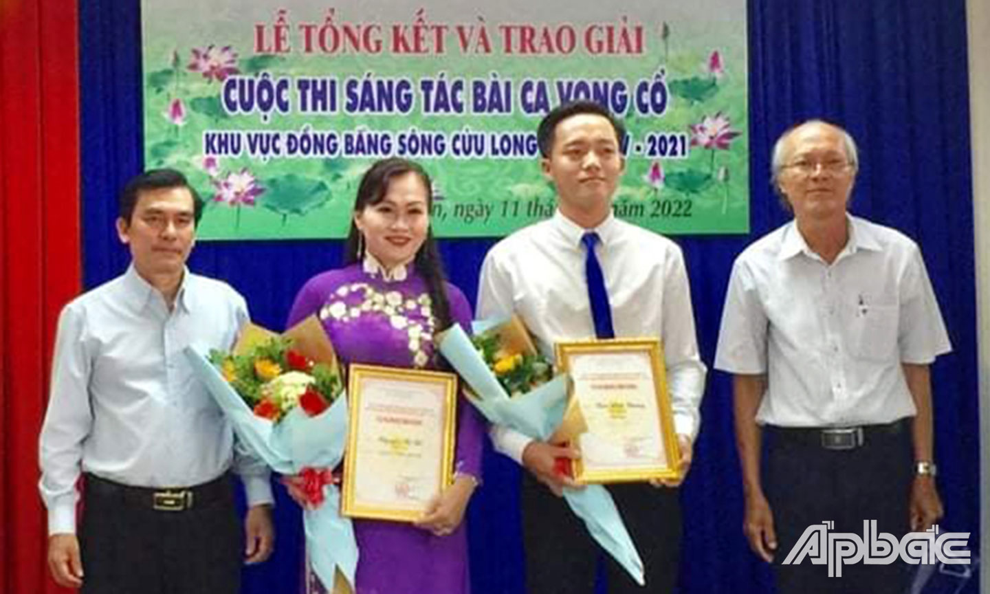 Chủ tịch  Hội Liên hiệp  Văn học -  Nghệ thuật  tỉnh Long An Nguyễn Tấn Quốc  và giám khảo  Cuộc thi -  soạn giả  Diệp Vàm Cỏ -  trao giải Nhì  cho tác giả  Trần Vĩnh Trường  và Nguyễn Thị Bé.