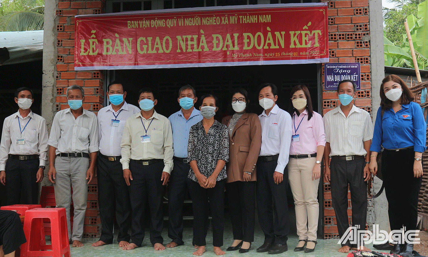 Chị Võ Thị Lùng chụp ảnh lưu niệm cùng các đại biểu bên ngôi nhà mới