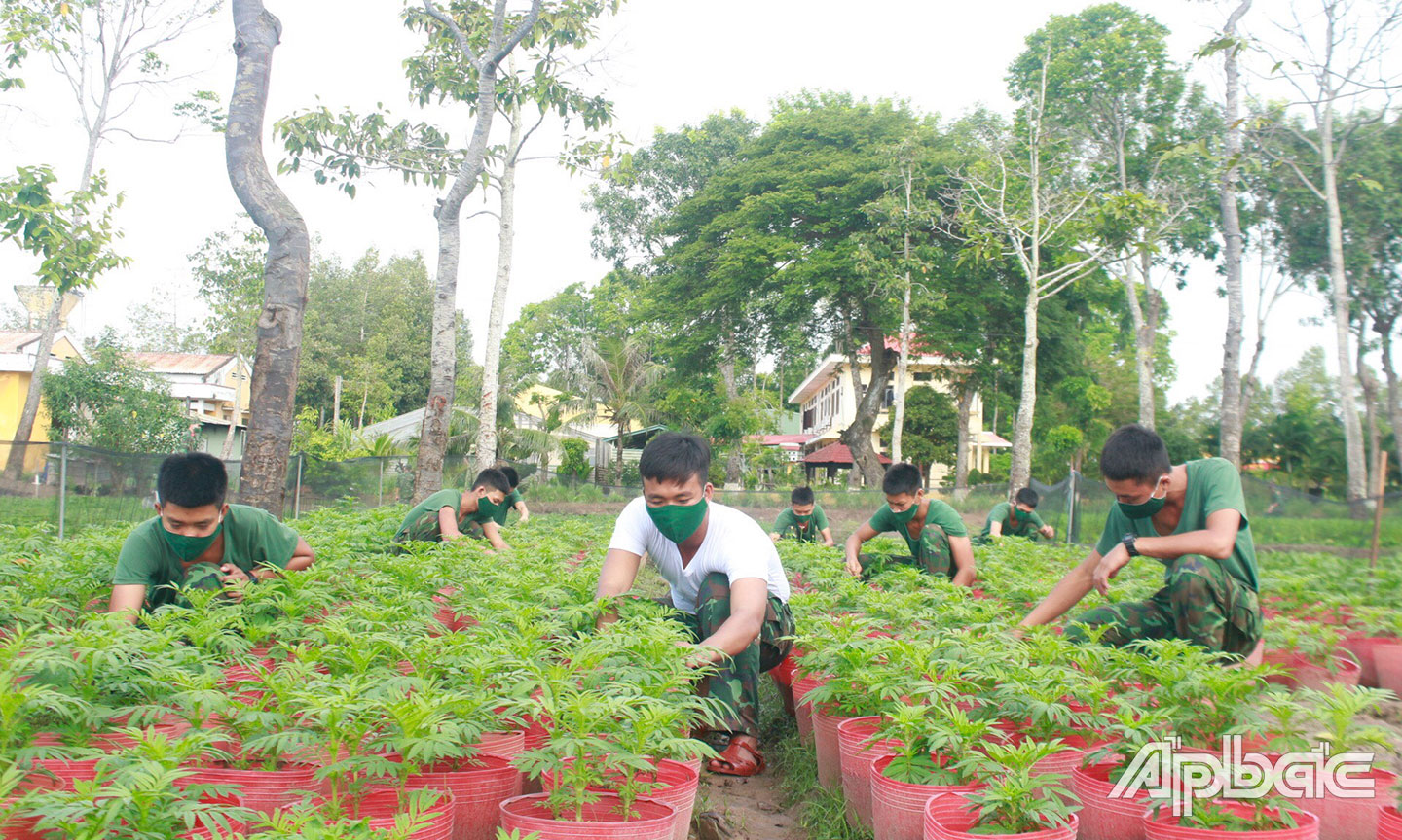 Trung úy Lâm Trọng Nghĩa (Áo trắng)  cùng các chiến sĩ chăm sóc hoa tết 2022.