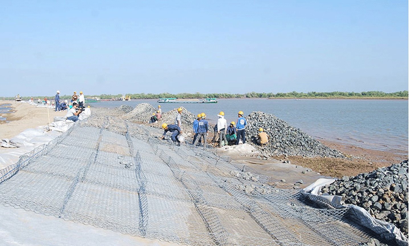 Công nhân lắp đặt các rọ đá chống sạt lở ven bờ cho luồng tàu biển trọng tải lớn vào sông Hậu.