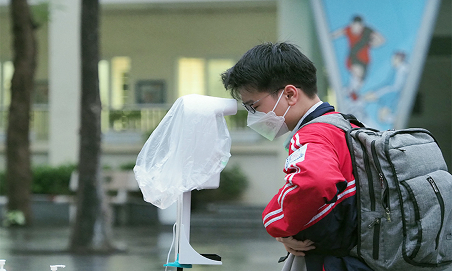 Học sinh Trường THCS Dịch Vọng, quận Cầu Giấy (Hà Nội) thực hiện khai báo y tế, khử khuẩn và đo thân nhiệt trước khi vào lớp học. (Ảnh TUẤN ANH)