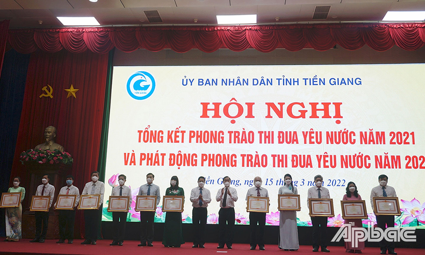 Đại diện xã Bình Tân (bìa trái) nhận Bằng khen của Thủ tướng Chính phủ tại Hội nghị tổng kết phong trào thi đua yêu nước năm 2021 và phát động  phong trào thi đua yêu nước năm 2022 do UBND tỉnh tổ chức.					Ảnh: NGỌC AN