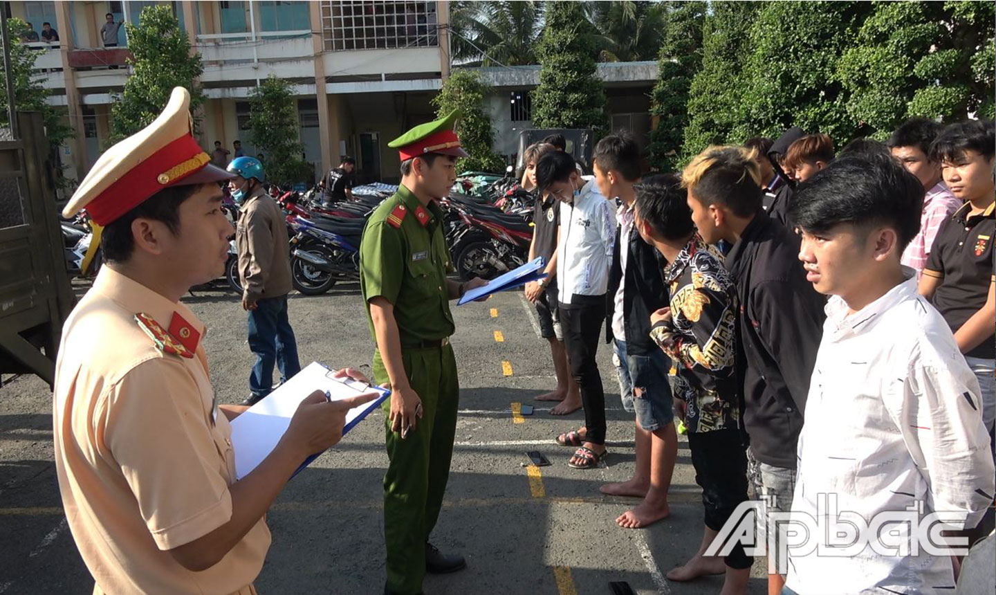 Công an TX. Cai Lậy làm việc với các đối tượng đua xe trái phép. 	Ảnh: THANH VIỆT